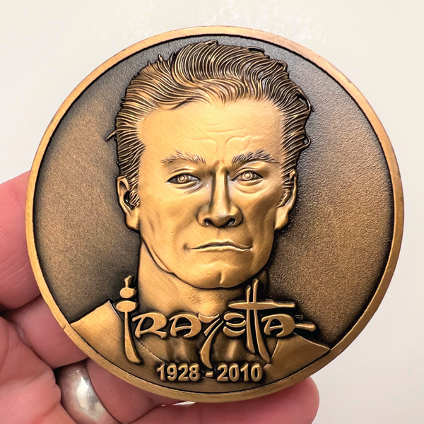 Load image into Gallery viewer, Copper metal coin in hand showing Frazetta portrait, name, and years 1928-2010