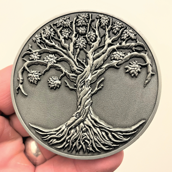 Load image into Gallery viewer, Silver metal coin in hand showing Tree of Life
