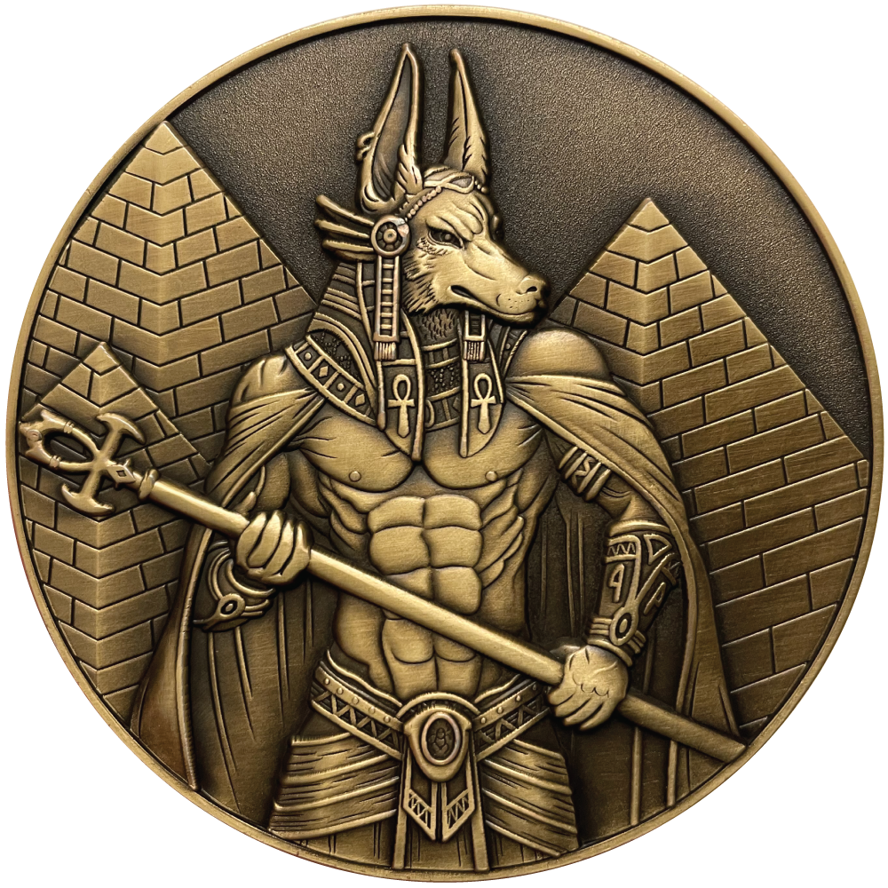 Gold metal coin showing Anubis next to pyramids