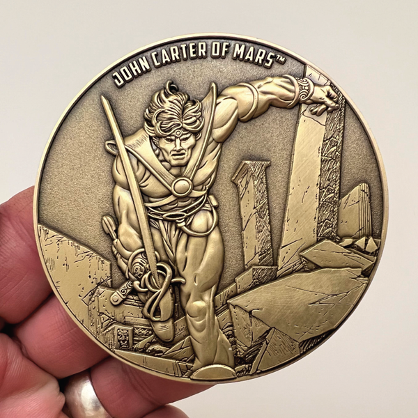 Load image into Gallery viewer, Gold metal coin in hand showing John Carter of Mars