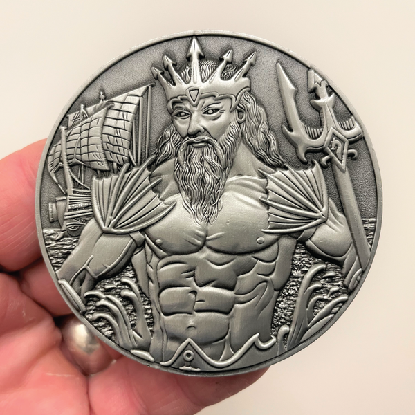 Load image into Gallery viewer, Silver metal coin in hand showing Poseidon
