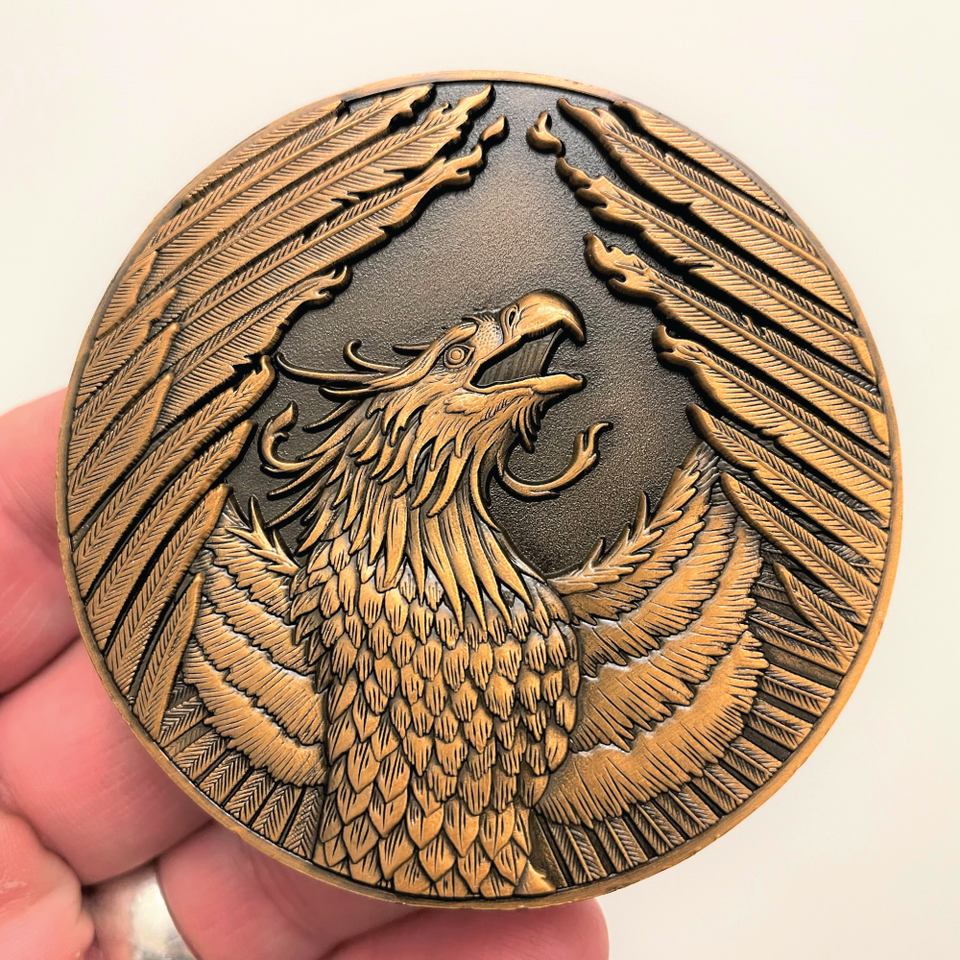 Copper metal coin showing a Phoenix which a winged fiery bird