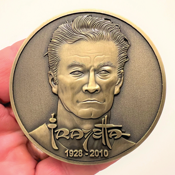 Load image into Gallery viewer, Gold metal coin in hand showing Frank Frazetta portrait, his name, and year 1928-2010
