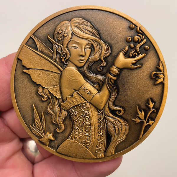 Load image into Gallery viewer, Copper metal coin in hand showing Fairy with frog
