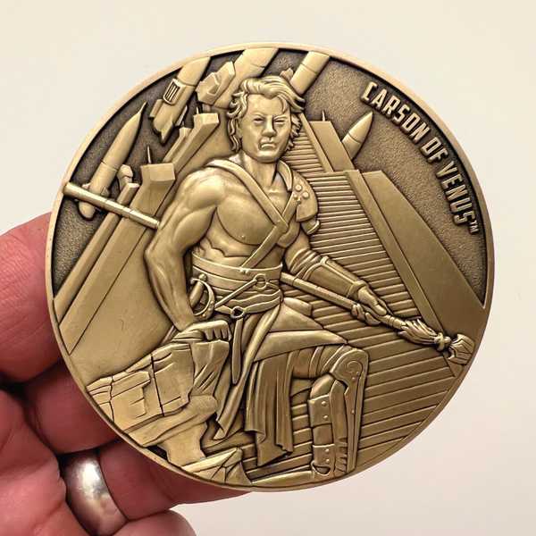 Load image into Gallery viewer, Gold metal coin in hand showing Carson of Venus
