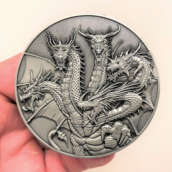 Load image into Gallery viewer, Silver metal coin in hand showing Five Headed Dragon
