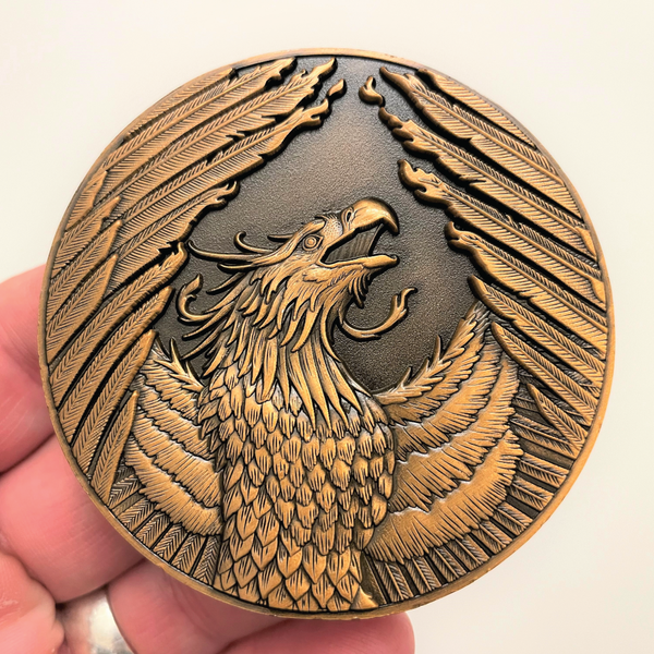Load image into Gallery viewer, Copper metal coin in hand showing Phoenix
