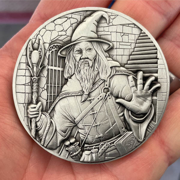 Load image into Gallery viewer, Silver painted coin in hand showing wizard
